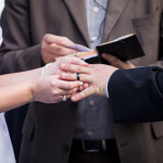 Bride Placing Wedding Ring on Groom's Finger Image